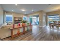 Bright, open-concept living room featuring hardwood floors, neutral decor, and access to the patio at 51 Reflection Cove Dr, Henderson, NV 89011