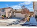 Charming single-story home with a two-car garage, tile roof, desert landscaping and sidewalk at 8453 Garnet Peak Ct, Las Vegas, NV 89117