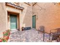 Private courtyard with brick pavers, string lights, seating, and two exterior doors at 8834 Sherborne Gate Ave, Las Vegas, NV 89148