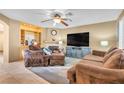 Cozy living room featuring a fireplace, built-in shelving, and comfortable seating area with ceiling fan at 9836 La Vid Ct, Las Vegas, NV 89117