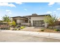 Modern home with a well-manicured front yard, a stone facade, and a glass garage door at 12103 Canyon Sunset St, Las Vegas, NV 89138