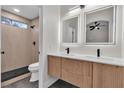 Contemporary bathroom with double sinks, backlit mirrors, and a walk-in shower with black tile floor at 1820 Montvale Ct, Las Vegas, NV 89134