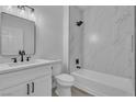 Bathroom features marble tiling, white vanity with modern black hardware, and shower over tub at 3318 N Decatur Blvd # 1035, Las Vegas, NV 89130