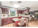 Bright kitchen features dark cabinetry, a skylight, and a center island with seating at 3696 Monte Verde St, Las Vegas, NV 89121