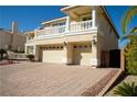 Spacious home featuring a three-car garage and elegant balconies, complemented by a brick driveway at 4384 Grey Spencer Dr, Las Vegas, NV 89141