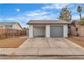 Front view of a house with a gray roll-up garage door and a carport at 4769 Via Renaldo, Las Vegas, NV 89103