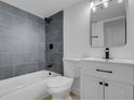 Bathroom featuring a tub with gray tile surround, modern vanity, and stylish fixtures at 4825 Randall Dr, Las Vegas, NV 89122