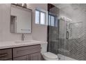 Modern bathroom features a herringbone-tiled shower and a vanity with a sleek, minimalist design at 613 W Victory Rd, Henderson, NV 89015