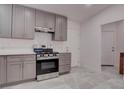 Well-lit kitchen with stainless steel appliances, gray cabinetry, and white countertops at 613 W Victory Rd, Henderson, NV 89015