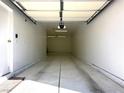 Bright, clean one car garage with white walls, lights, and concrete flooring at 10001 Peace Way # 2353, Las Vegas, NV 89147