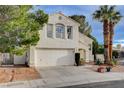 Inviting two-story home with attached two car garage, complimented by palm trees at 2504 Cove Rd, Las Vegas, NV 89128