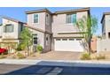 Attractive two-story home featuring a clean exterior, a paved driveway, a two-car garage, and lovely front yard landscaping at 26 Lilla Rosa St, Henderson, NV 89011