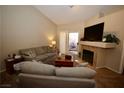 Bright living room with fireplace, vaulted ceiling, and sliding glass doors at 379 Rosado Springs St, Henderson, NV 89014