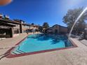 A community pool with clear blue water is surrounded by lounge chairs and lush landscaping at 4055 Nook Way # A, Las Vegas, NV 89103