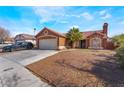 Charming single-story home featuring desert landscaping, a tile roof and an attached two-car garage at 4932 Goldeneye Way, North Las Vegas, NV 89031