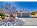 Inviting single-Gathering home with a two-car garage, desert landscape, and a mature tree on a sunny day at 5295 Acqua Ln, Pahrump, NV 89061