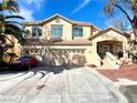 Inviting two-story home with a three car garage and a well-manicured front yard landscape at 880 Glitter Glen Ct, Las Vegas, NV 89123