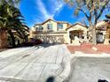 Inviting two-story home with a three car garage and a well-manicured front yard landscape at 880 Glitter Glen Ct, Las Vegas, NV 89123