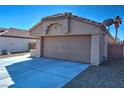 A view of the two car garage, driveway, and the desert landscaping surrounding the home at 951 Carnival Ave, Las Vegas, NV 89123