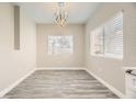 Dining room with a modern chandelier, wood floors, and natural light from the window at 1050 E Cactus Ave # 1049, Las Vegas, NV 89183