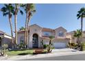 Elegant two-story house with stucco exterior, tile roof, palm trees, and a well-manicured front yard at 2008 Arbor Forest St, Las Vegas, NV 89134