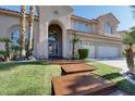 Inviting home with a well-kept lawn, palm trees, and a charming front entrance with a tiled walkway at 2008 Arbor Forest St, Las Vegas, NV 89134