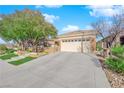 Beautiful home with a well-kept yard, mature trees, and a spacious driveway leading to a two-car garage at 2244 Garden City Ave, Henderson, NV 89052