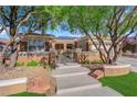 Welcoming front entrance with an iron gate, stone accents, and steps leading to the front door at 2244 Garden City Ave, Henderson, NV 89052