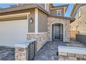 Stunning front entrance with arched stone detail, and a paved walkway leading to the door at 225 Sul Ponticello Ave, Las Vegas, NV 89011