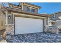 Close up of the home's two-car garage door and stone veneer pillar detail at 225 Sul Ponticello Ave, Las Vegas, NV 89011