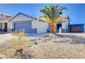 Single-story home with desert landscaping, concrete driveway, and a gray two car garage at 2345 Steinke Ln, Las Vegas, NV 89108