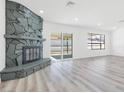 Bright living room with a cozy fireplace and large sliding glass doors leading to the backyard at 2415 La Estrella St, Henderson, NV 89014