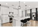 Bright kitchen featuring white cabinetry, stainless steel appliances, pendant lighting and a large island with seating at 2724 High Echelon Rd, North Las Vegas, NV 89086