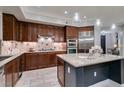 This kitchen features dark wood cabinets, granite countertops, and stainless steel appliances at 30 Via Mantova # 202, Henderson, NV 89011