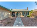 Welcoming entrance with arched details, desert landscaping, and a well-maintained facade with a neutral color scheme at 3730 Greenwood Dr, Las Vegas, NV 89103