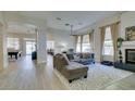 Bright living room featuring wood floors, a fireplace, and large windows with plenty of natural light at 4635 Bird View Ct, Las Vegas, NV 89129