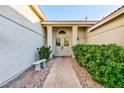 Inviting front entrance featuring double doors flanked by mature bushes and a stone bench at 5601 Cavalier Cir, Las Vegas, NV 89130