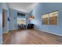 This dining area features a stylish light fixture, blue walls and wood-look flooring at 5976 Ancona Dr, Las Vegas, NV 89141