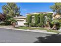 Beautiful single-story home featuring a two-car garage, brick driveway, and manicured landscaping at 613 Pinnacle Heights Ln, Las Vegas, NV 89144