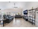 Spacious living room with vaulted ceilings, tile floors, comfortable seating, and a modern entertainment center at 6608 Ringbill Ct, North Las Vegas, NV 89084