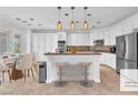 Bright kitchen boasts white cabinetry, stainless steel appliances, and a breakfast bar with stylish pendant lighting at 8629 Estrelita Dr, Las Vegas, NV 89128