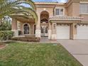 Inviting two-story home featuring manicured landscaping, a covered porch, and a three-car garage at 8970 Lansberry Ct, Las Vegas, NV 89147