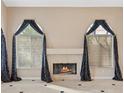 Bright living room showcasing a fireplace, large windows with decorative curtains, and tiled floors at 8970 Lansberry Ct, Las Vegas, NV 89147