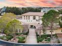 Stately home with a tile roof, lush landscaping, and a grand stone archway over the driveway at 9325 Verlaine Ct, Las Vegas, NV 89145