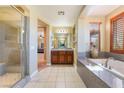 Bathroom with a glass enclosed shower, soaking tub, and dual vanity at 1059 Via Saint Lucia Pl, Henderson, NV 89011