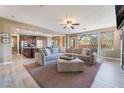 Open-concept living room with a large sectional sofa, plush rug, and views of the backyard at 1059 Via Saint Lucia Pl, Henderson, NV 89011