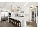 Modern kitchen featuring stainless steel appliances, an oversized island with seating and stylish pendant lighting at 12217 Tempestad Ave, Las Vegas, NV 89138