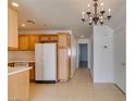 A well-lit kitchen area featuring tile floors, wooden cabinets, and essential appliances at 2049 Audrey Hepburn St, Las Vegas, NV 89142