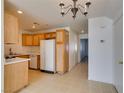 A well-lit kitchen area featuring tile floors, wooden cabinets, and essential appliances at 2049 Audrey Hepburn St, Las Vegas, NV 89142