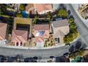 Aerial view of a home with a well-manicured backyard with artifical turf, and solar panels on the roof at 2176 De Narvik Dr, Henderson, NV 89044